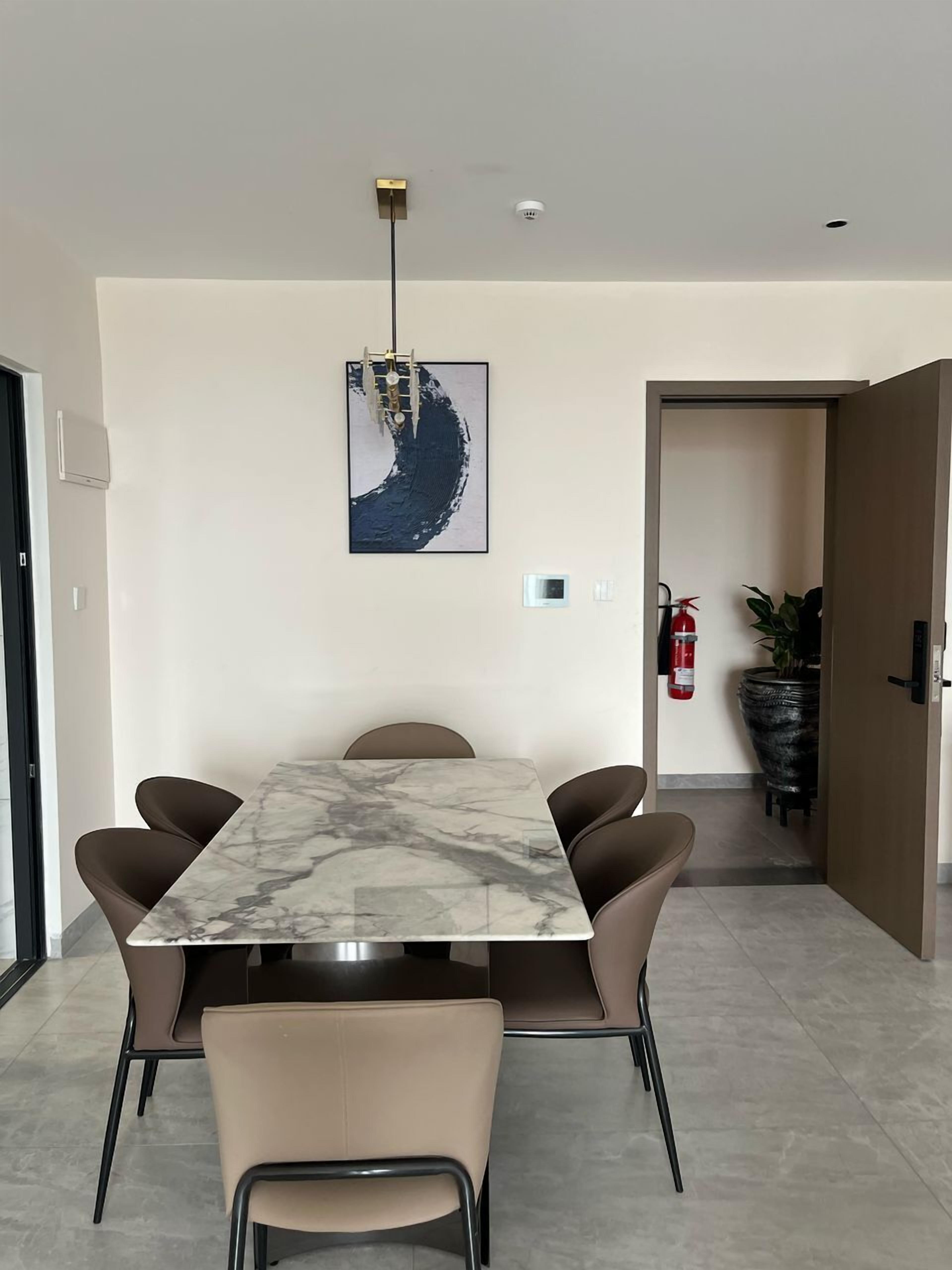 Un espace repas moderne avec une table en marbre et six chaises.