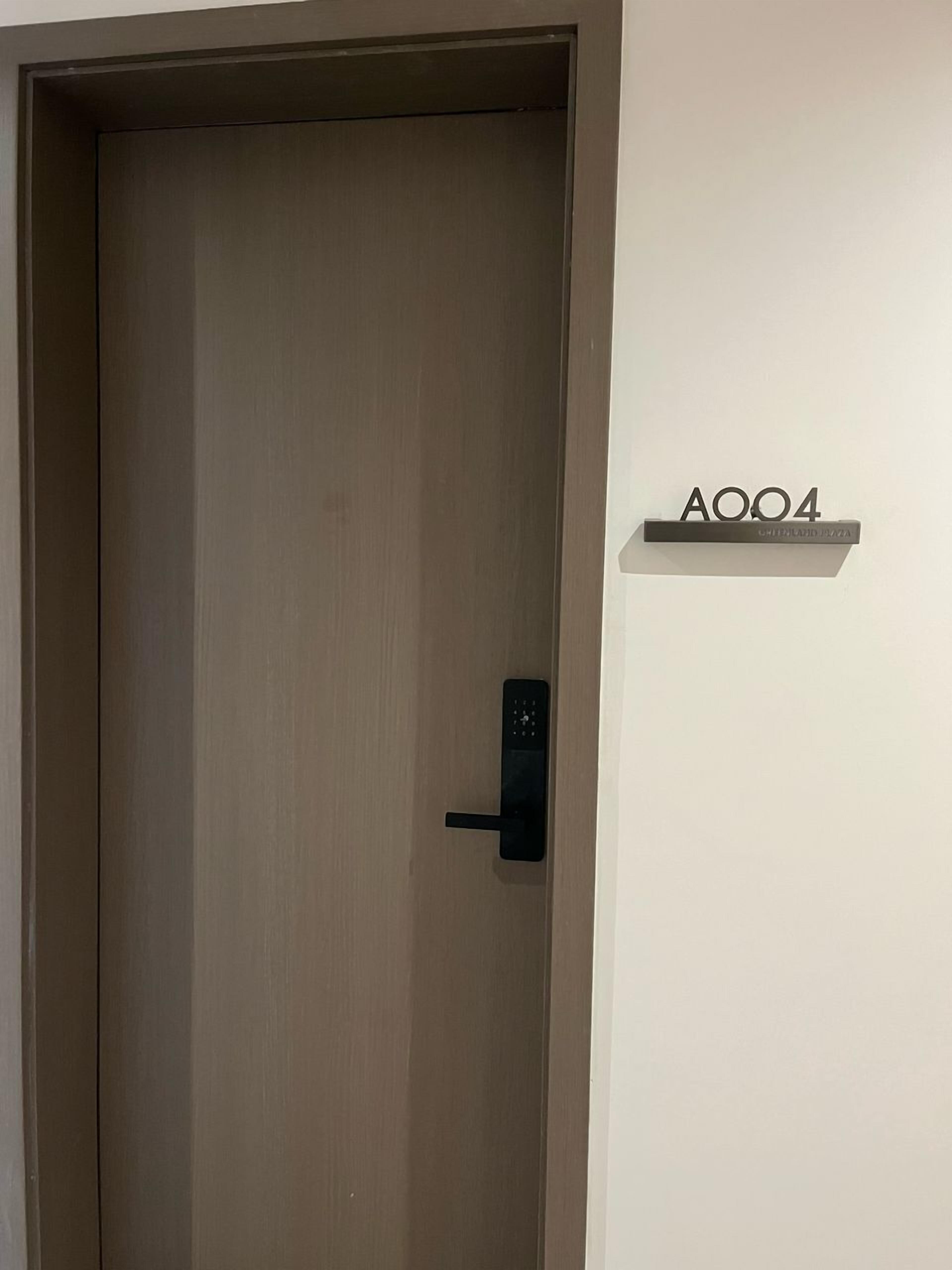 A closed door with a modern electronic lock and a sign above it reading "A004".