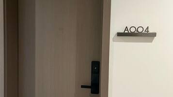 A closed door with a modern electronic lock and a sign above it reading "A004".