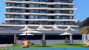 A multi-story hotel with balconies, a swimming pool, and outdoor seating areas. - Kigali Greenland Serviced Apartments (Kigali)