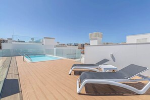 A rooftop pool area with lounge chairs and a glass balustrade. - Chic and central brand new apartment by Tenório (Lagos)