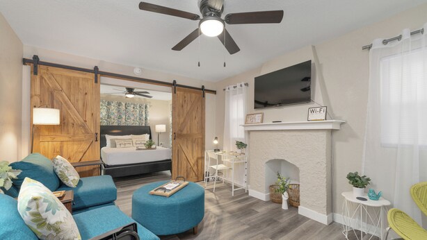 A modern living room with a sofa, ottoman, and a fireplace. - Centrally Located Near Downtown W/ In Unit W&D! (Wichita)