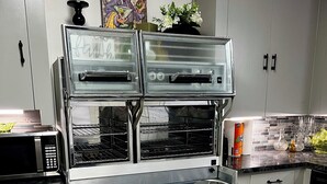 Cozinha com forno duplo, eletrodomésticos de aço inoxidável e painel de azulejos.