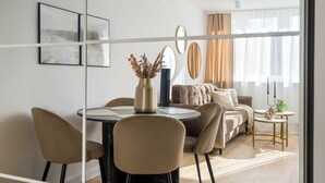 Een moderne woonkamer met een eethoek, een bank en een bijzettafeltje met een vaas.