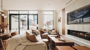 A modern living room with a sofa, chairs, a coffee table, and a fireplace. - Lift 102 -ski in/out (30 sec. walk, patio to lift) (Park City)