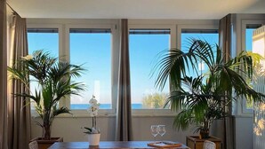Ein Essbereich mit einem Holztisch, zwei Stühlen und Topfpflanzen.