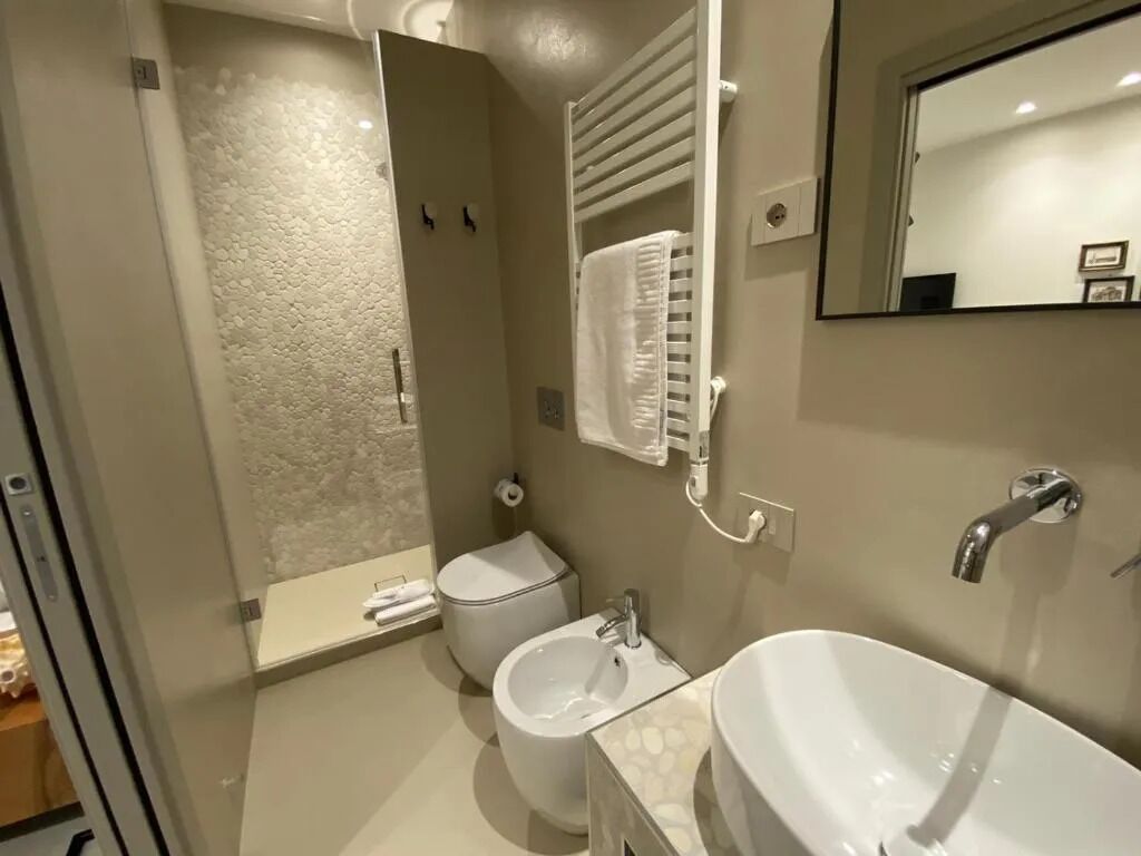 A modern bathroom with a toilet, bidet, and a large sink.