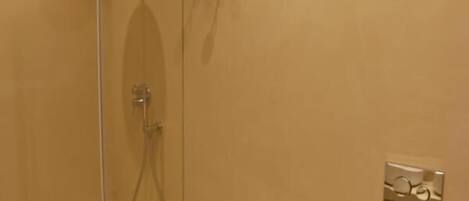 Een badkamer met een douchecabine, een bidet, een toilet en een wastafel.