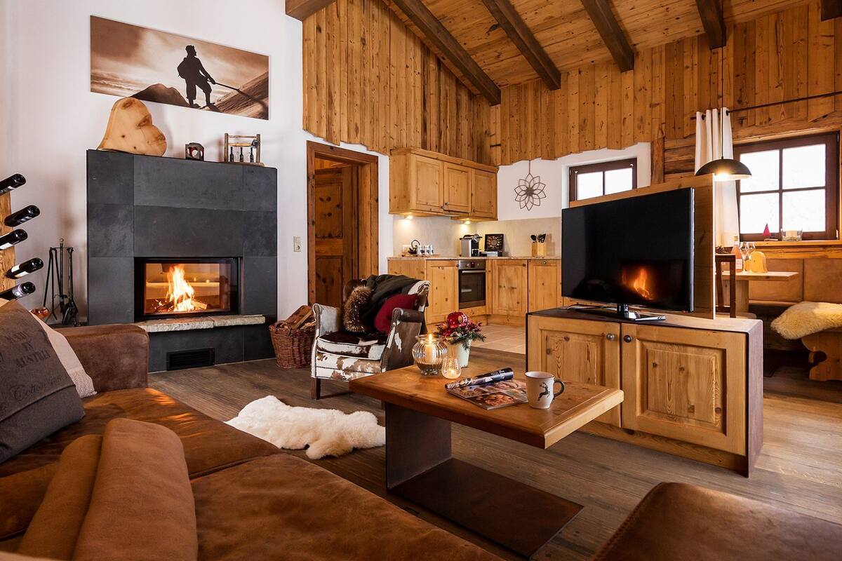 A cozy living room with a fireplace, wooden furniture, and a television.