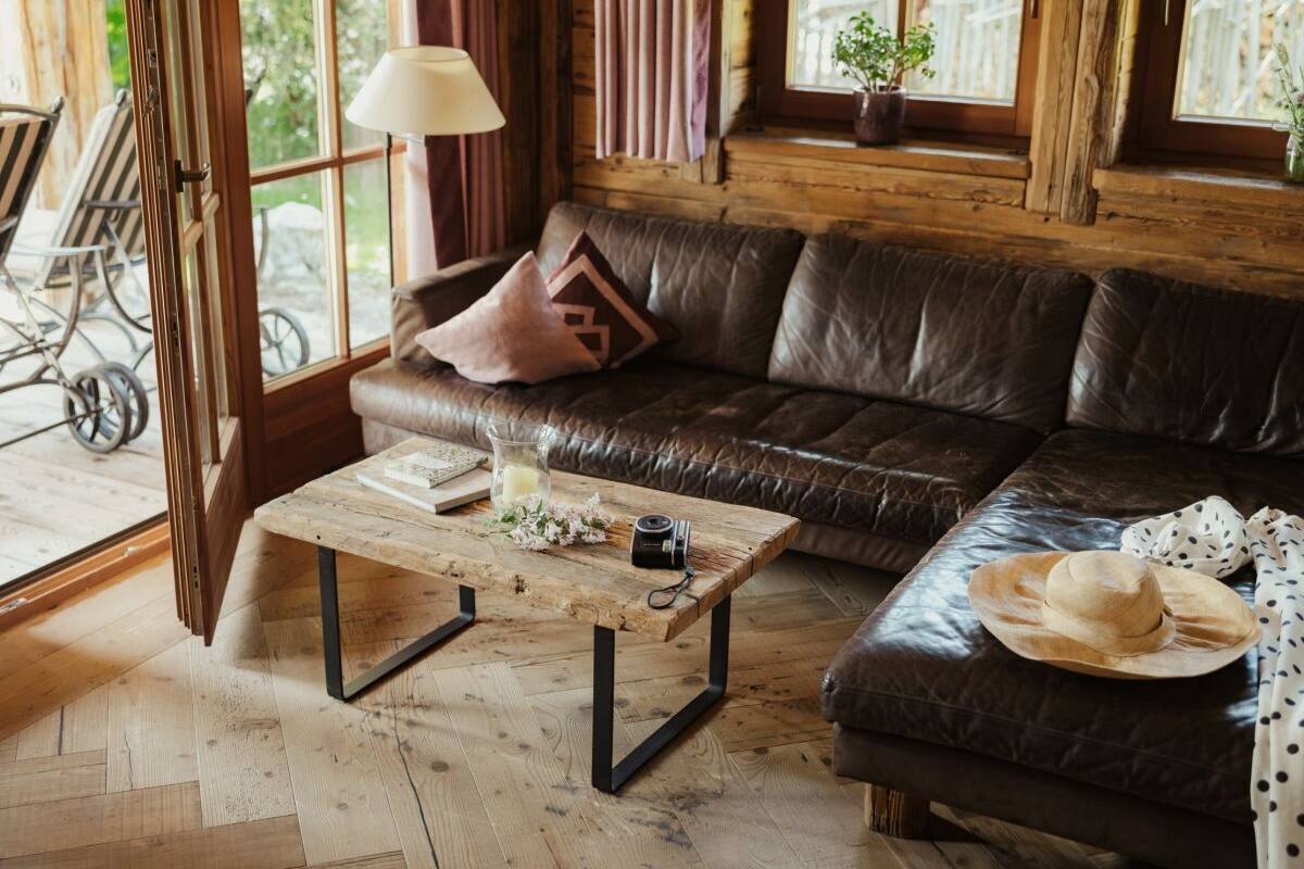 A cozy living room with a leather sofa, a wooden coffee table, and a lamp.