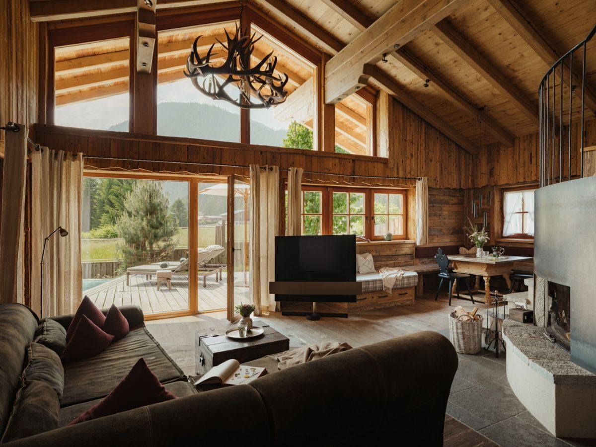 A spacious living room with a large TV, wooden furniture, and a fireplace.