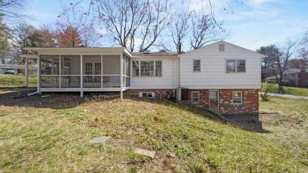 A two-story house with a covered porch and a brick section.
