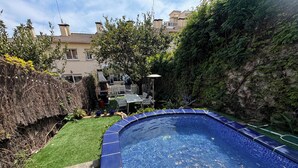 A swimming pool with a blue tiled edge, surrounded by a well-maintained lawn and a hedge. - HOUSE IN MASNOU NEXT TO BEACH AND TRAIN (El Masnou)