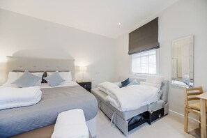 Een moderne slaapkamer met twee bedden, een nachtkastje, een stoel en een groot raam met uitzicht.