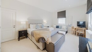 A modern bedroom with a bed, bedside tables, a desk, and a television. - Mayfair Oxford Street by Estatesmen (London)