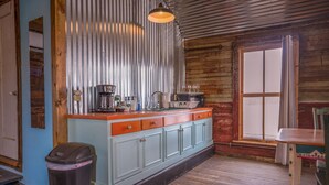 A kitchen with a wooden countertop, a coffee maker, and a trash can. - Leaning Tower of Alpine (Alpine)