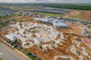 A large commercial building with a parking lot, landscaped areas, and a central courtyard with palm trees. - GO 35 - Windsor CAY (Clermont)