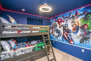 A bunk bed with a ladder, a ceiling fan, and a wall mural of superheroes. - GO 35 - Windsor CAY (Clermont)