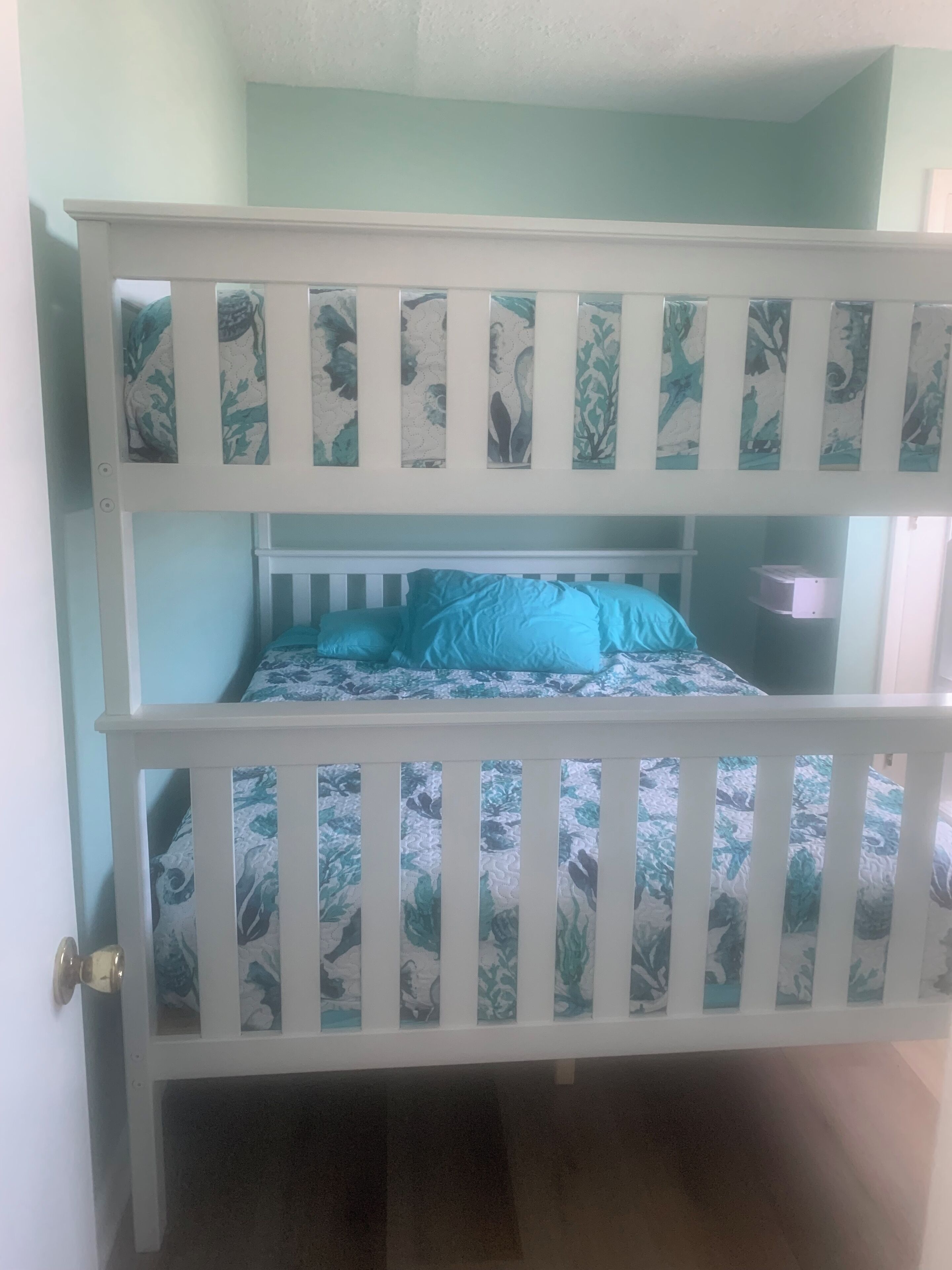 A bunk bed with a floral-patterned headboard and matching pillows.