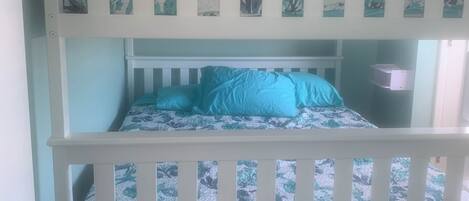 A bunk bed with a floral-patterned headboard and matching pillows.