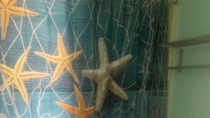 Ein Badezimmer mit blauem Vorhang, Sterndekorationen und einer Toilette.