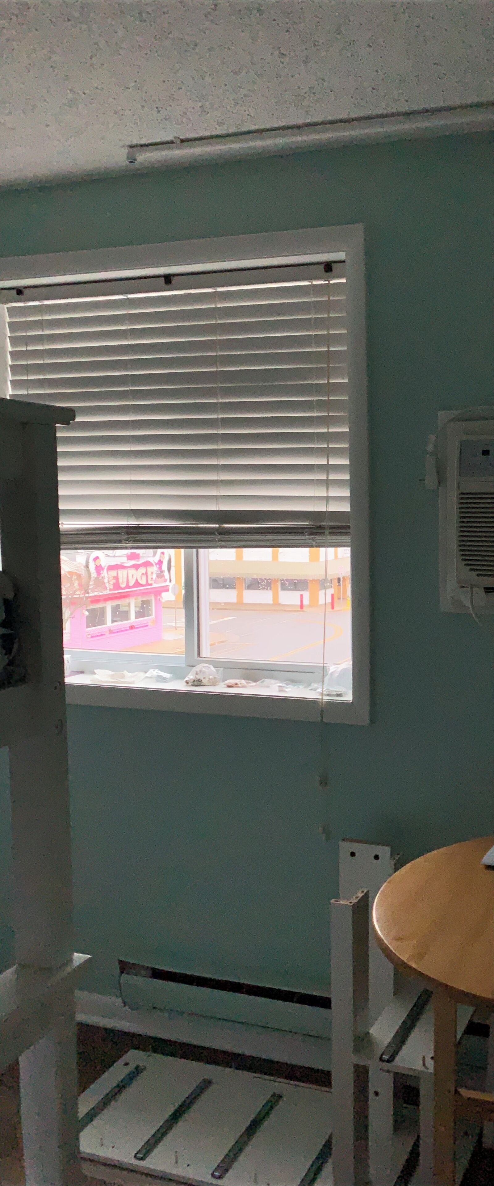 A room with a window, a table, and a chair.