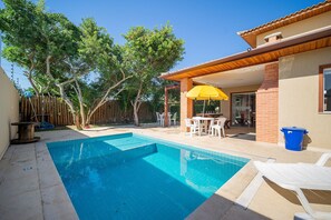 A backyard with a swimming pool, patio furniture, and a covered seating area. - Bz38 Casa a 200m praia piscina privativa (Buzios)