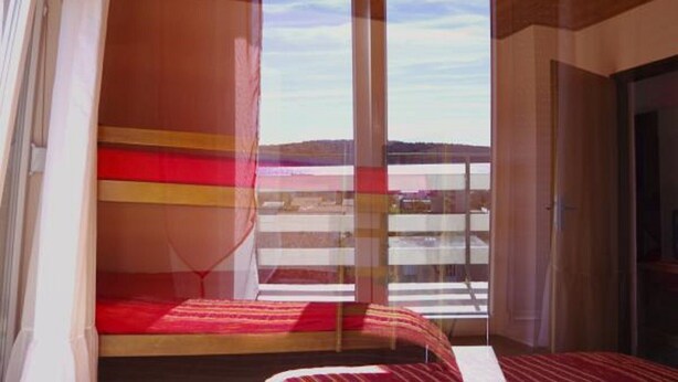 Une pièce avec un lit, une fenêtre et une vue sur l’extérieur.