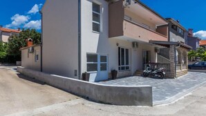 A two-story residential building with a flat roof, a covered porch, and a paved driveway. - Charming Zadar Apartment Near Old Town with Convenient Access to Beaches Apartman ( 2 ) (Zadar)
