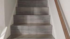 A staircase with wooden steps and a wooden handrail. - Cowboy Oasis !King Bed with WiFi by Domain (Austin)