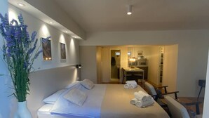 A modern hotel room with a large bed, a desk, and a kitchenette. - La Dolce Nikka - Apartment (Rovinj)