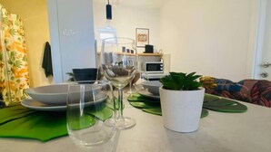 A dining area with a table set for two, a microwave, and a small potted plant. - La Dolce Nikka - Apartment (Rovinj)
