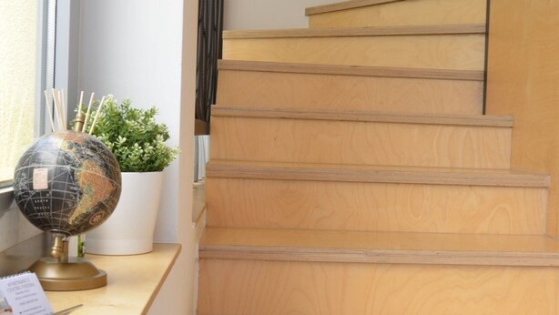 Een houten trap met een wereldbol en een plant op een bureau.