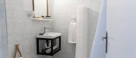 A modern bathroom with a toilet, sink, and shower.