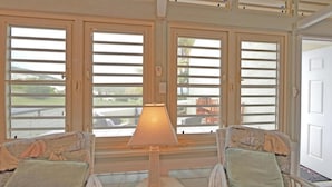 Una habitación con vista a un patio, una lámpara y dos sillas.