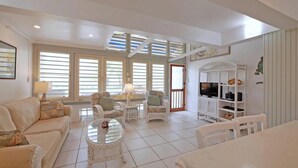 Un salón amplio con sofá, sillones, una mesa de centro y un mueble para la televisión.