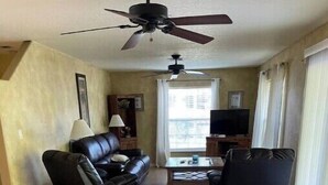 A living room with a sofa, a chair, a coffee table, and a TV. - Cisky Park Leesburg over looking Lake Harris (Leesburg)