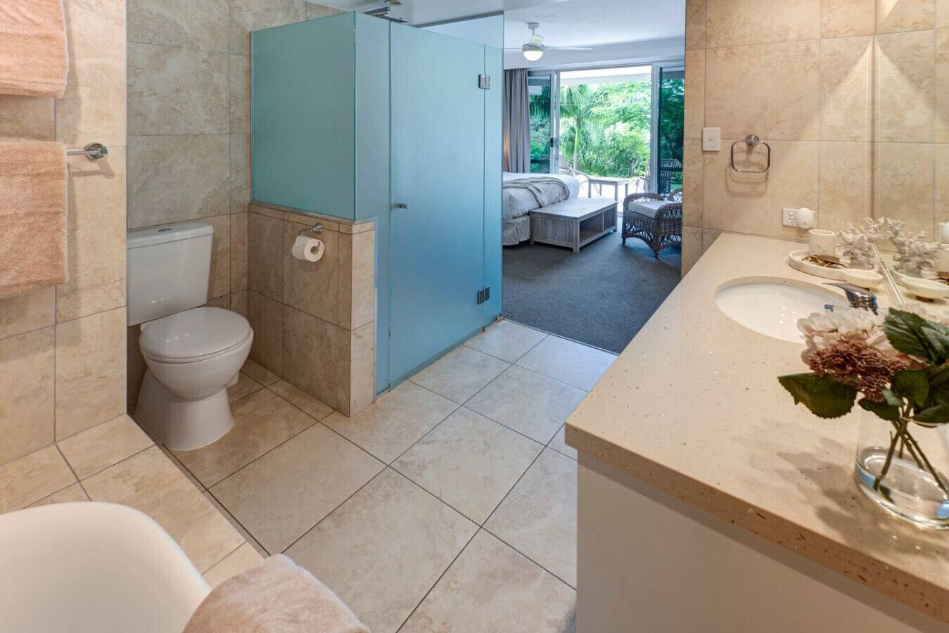 Une salle de bain comprenant des toilettes, un lavabo et un espace douche.