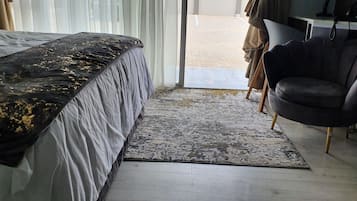 Une chambre à coucher avec un lit, une chaise, un tapis et une vue sur l’extérieur.