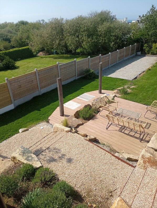 A patio area with a wooden deck, outdoor furniture, and a view of the surrounding landscape. - House with a garden, 500 meters from the beach (Plouarzel)