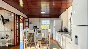A compact kitchen with white cabinets, a microwave, and a Bosch refrigerator. - Casa Aconchegante na Lagoa de Ibiraquera (Imbituba)