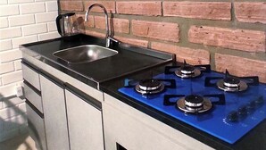 Une cuisine équipée d’une cuisini ère à gaz, d’un four à micro-ondes et d’un évier.