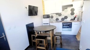 A compact kitchen with a dining area, a built-in oven, and a flat-screen TV. - House sleeps 4 (Saint-Léger-sous-Brienne)