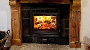 A fireplace with a wooden mantel, a mirror above it, and two candles on the mantel.
