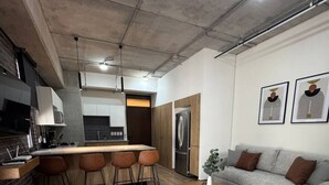 Une cuisine moderne dotée d’un îlot central, de tabourets de bar et d’un réfrigérateur.