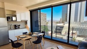 A modern kitchen with a dining area, large windows, and a view of the city. - New apartment Nous 606 (Guadalajara)