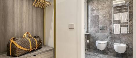 Un baño moderno con ducha a nivel de suelo, lavamanos dobles y un perchero para toallas.