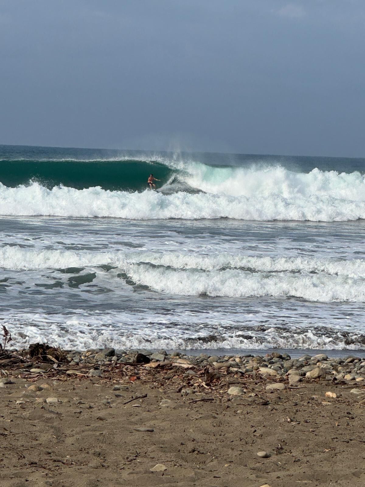Une plage avec des vagues et un surfeur.