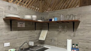 Une cuisine équipée d’un évier, de meubles en bois et d’un panneau indiquant « Eau non potable ».