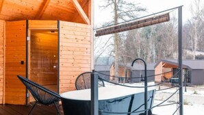 A wooden cabin with a hot tub and chairs on a deck. - Halicanum Glamping Peaceful Retreat Resort (Sveti Martin na Muri)